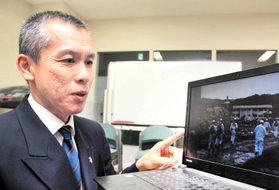 当時の写真を見返し、教訓を語る宗則悦夫さん＝姫路市防災センター