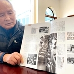 東芝姫路工場の社史を見て思い出を語る山田正典さん＝姫路市余部区下余部