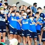 スタンドから声援を送るサッカー少女たち。ピッチを駆ける選手に自分の未来を重ねる＝１０日、ウインク陸上競技場