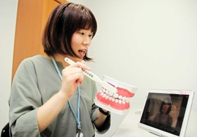 画面越しに子どもの歯の磨き方を助言する歯科衛生士＝姫路市坂田町