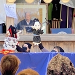 お菊が井戸から現れる場面を披露する人形劇＝十二所神社
