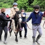 指導員が手綱を引くポニーにまたがり、乗馬を楽しむ高齢者＝姫路市夢前町山之内