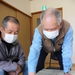公民館で見つかった図面を広げ、延伸予定地について説明する山田正典さん（右）ら＝姫路市余部区下余部