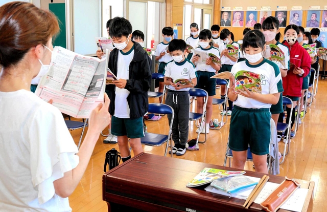 マスクを着用したまま合唱する６年生の児童＝野里小学校