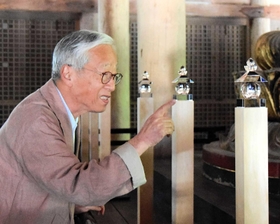 阿弥陀如来の周囲に配置したガラスの「五輪塔」について説明する杉本博司さん＝書写山円教寺