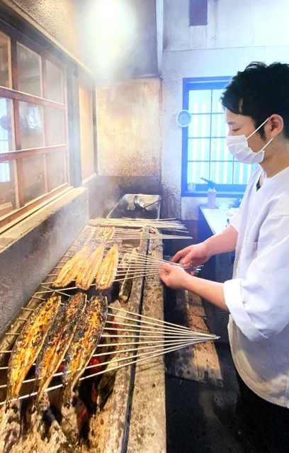 焼き場に立ち、ウナギを焼く堀部龍登さん＝姫路市飾西
