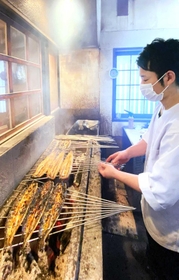 焼き場に立ち、ウナギを焼く堀部龍登さん＝姫路市飾西