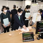 小児型のシミュレーターを使った心肺蘇生を見学する参加者ら＝県立大先端医療工学研究所
