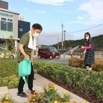 ロータリーの花や芝生に水をやる地域住民たち＝姫路市相野