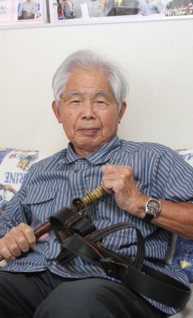 兵学校での日々を語る山室國康さん。手にした短剣は入学時に与えられた＝姫路市
