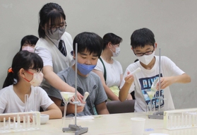 高校生らの指導を受けながら、実験に取り組む子どもたち＝姫路市書写