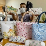 鮮やかなデザインが映える姫革細工を手にする水田久司さん＝キャッスルレザー