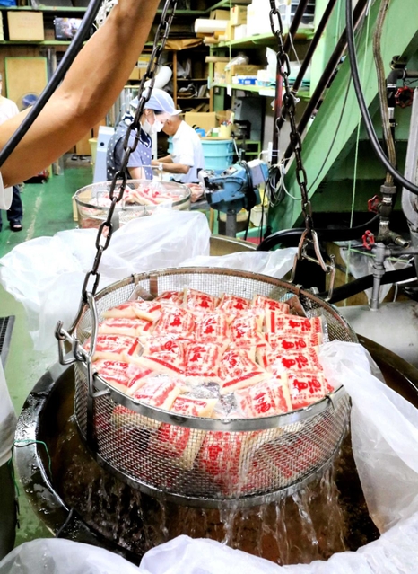 パック詰めして熱湯殺菌される甘酒＝姫路市白浜町甲