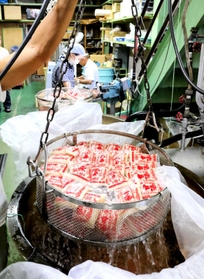 パック詰めして熱湯殺菌される甘酒＝姫路市白浜町甲