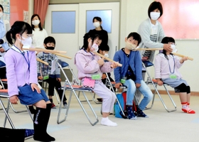 楽器の持ち方を学ぶ基礎練習。木の棒と発泡スチロールを組み合わせた道具をバイオリンに見立てる＝姫路市神子岡前３、面白山児童センター