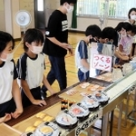回転ずしの体験ゲームを通じ、食品ロス問題を学ぶ児童ら＝谷外小学校
