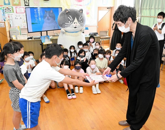作家の早見和真さんにかなしきデブ猫ちゃんの感想文を渡す児童たち＝水上小学校