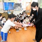 作家の早見和真さんにかなしきデブ猫ちゃんの感想文を渡す児童たち＝水上小学校