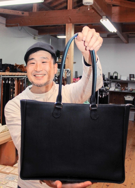 ジャパンレザーアワードで受賞したトートバッグを紹介する中野義夫さん＝姫路市花田町小川