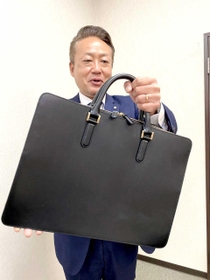 タァンネリルのバッグを手にアピールする戸田健一社長＝山陽