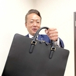 タァンネリルのバッグを手にアピールする戸田健一社長＝山陽