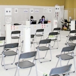 接種券などを確認する部屋は空席が目立つ。トラブルに対応する場所でもあり、ビブスを着たスタッフを多く配置している＝姫路市日出町３
