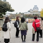 【姫路城を観光】ガイドの案内で姫路城を見学する参加者たち＝姫路市本町