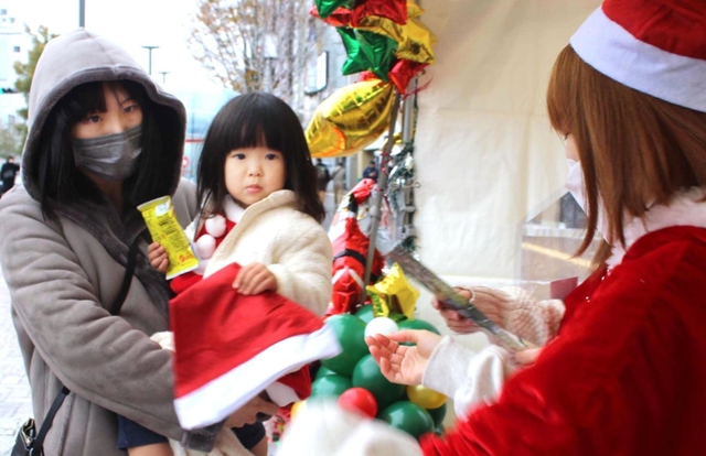 姫路駅前の芝生広場では、サンタ帽が無料で配られた＝姫路市駅前町
