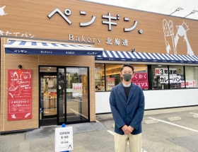 ペンギンベーカリー姫路野里店前に立つ牧野光樹専務。４店目は「よい物件があれば」＝姫路市野里