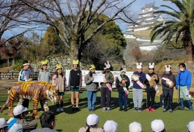 干支の引き継ぎ式で、ウサギを抱く児童たち＝姫路市立動物園