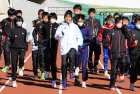 田中希実選手（中央）のウオーミングアップを間近で見ながら体を動かす中高生ら＝姫路市中地
