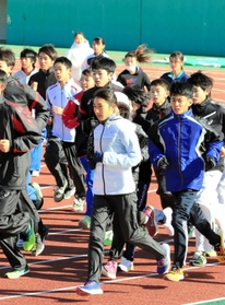 田中希実選手（中央）のウオーミングアップを間近で見ながら体を動かす中高生ら＝姫路市中地