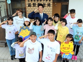 制服姿の福岡信哉さんとオリジナルＴシャツ姿のメンバー＝姫路市夢前町莇野