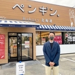 ペンギンベーカリー姫路野里店前に立つ牧野光樹専務。４店目は「よい物件があれば」＝姫路市野里