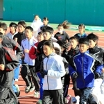 田中希実選手（中央）のウオーミングアップを間近で見ながら体を動かす中高生ら＝姫路市中地