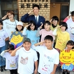 制服姿の福岡信哉さんとオリジナルＴシャツ姿のメンバー＝姫路市夢前町莇野