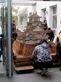 細心の注意を払って搬入されるお菓子の姫路城＝城内図書館（姫路市提供）