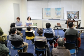 マルのはじまりの鐘の読み聞かせをする田中美子さんと、宮本裕美さん＝神戸新聞姫路本社