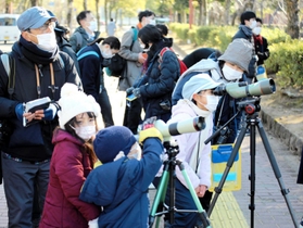 「いたいた」「見えた」。専用の望遠鏡を使って野鳥観察する参加者ら＝姫路市本町の姫路城周辺