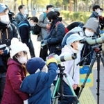 「いたいた」「見えた」。専用の望遠鏡を使って野鳥観察する参加者ら＝姫路市本町の姫路城周辺