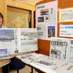 東日本大震災の津波被害などを伝える地方紙の切り抜きを並べる、養護教諭の中玉利展子さん＝高浜小学校
