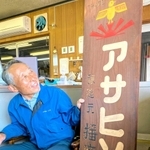 創業当時の看板を手にする小嶋昌一社長＝太子町矢田部