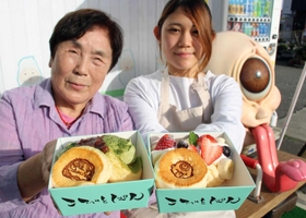 ガジロウや一つ目小僧の焼き印が押されたパンケーキを持つ、ヒサヤの前田久子代表（左）とこびとぱんの細越花菜店長＝福崎町南田原