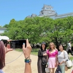 姫路城の天守群を背景に記念写真を撮る外国人観光客ら＝姫路市本町