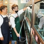 手動のポンプを使って水槽の掃除をする利用者（右）＝姫路市神屋町