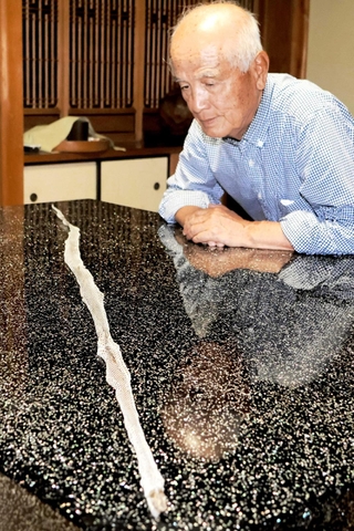 長さ約１６５センチのヘビの抜け殻と宝角隆義さん＝姫路市安田