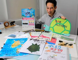 コンテストに寄せられた過去の作品を前に、応募を呼びかける田部勉さん＝姫路市白銀町、キョーリン