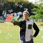 身近な道具で虹色の世界をつくり上げる「シャボン玉おじさん」＝姫路市太市中、桜山公園