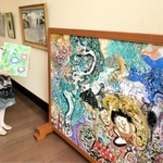 丸投三代吉の作品とスケッチブックを持つ丸尾三千代さん＝姫路市青山北３