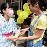 買い物客にレモネードを手渡す増田榮子さん（右）＝姫路市白銀町